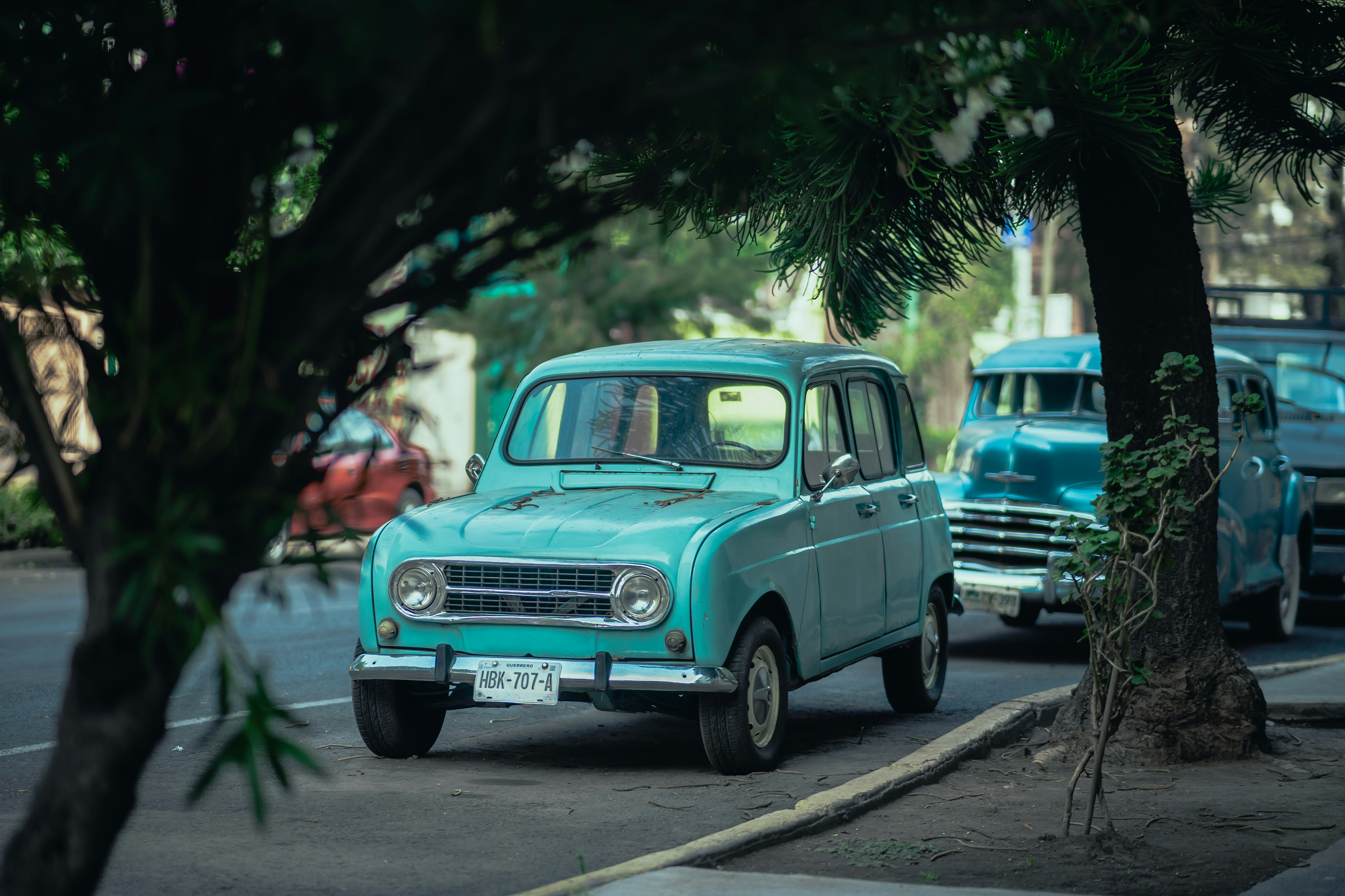 teal vintage car on road during daytime